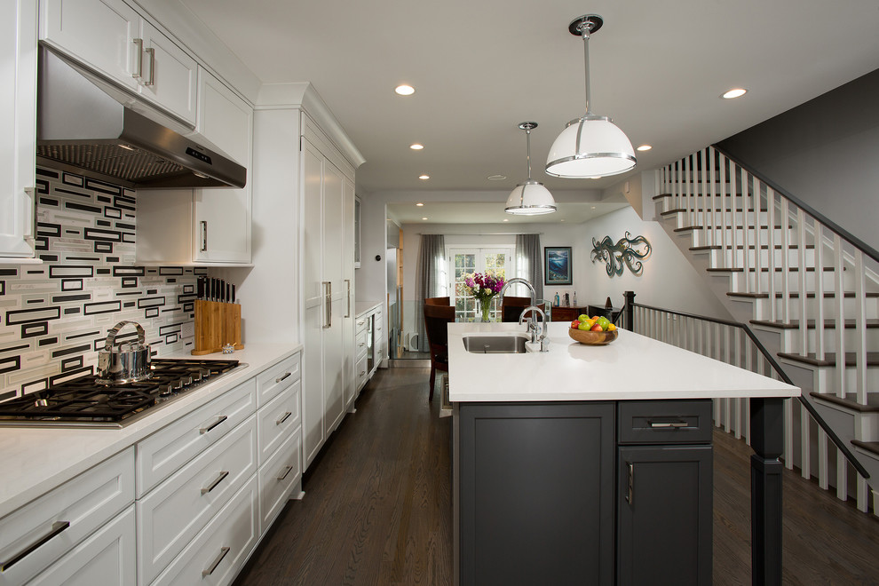 This is an example of a mid-sized transitional single-wall eat-in kitchen in DC Metro with an undermount sink, recessed-panel cabinets, white cabinets, quartz benchtops, black splashback, glass tile splashback, stainless steel appliances, dark hardwood floors and with island.