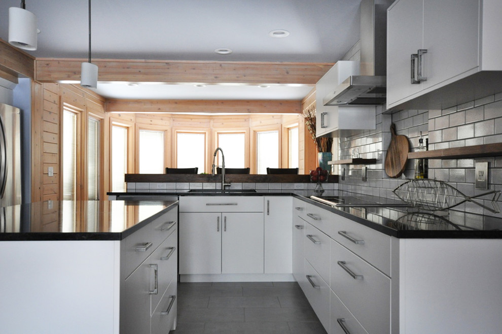 Mid-sized transitional l-shaped dark wood floor eat-in kitchen photo in Grand Rapids with an undermount sink, flat-panel cabinets, white cabinets, soapstone countertops, white backsplash, subway tile backsplash, stainless steel appliances and an island