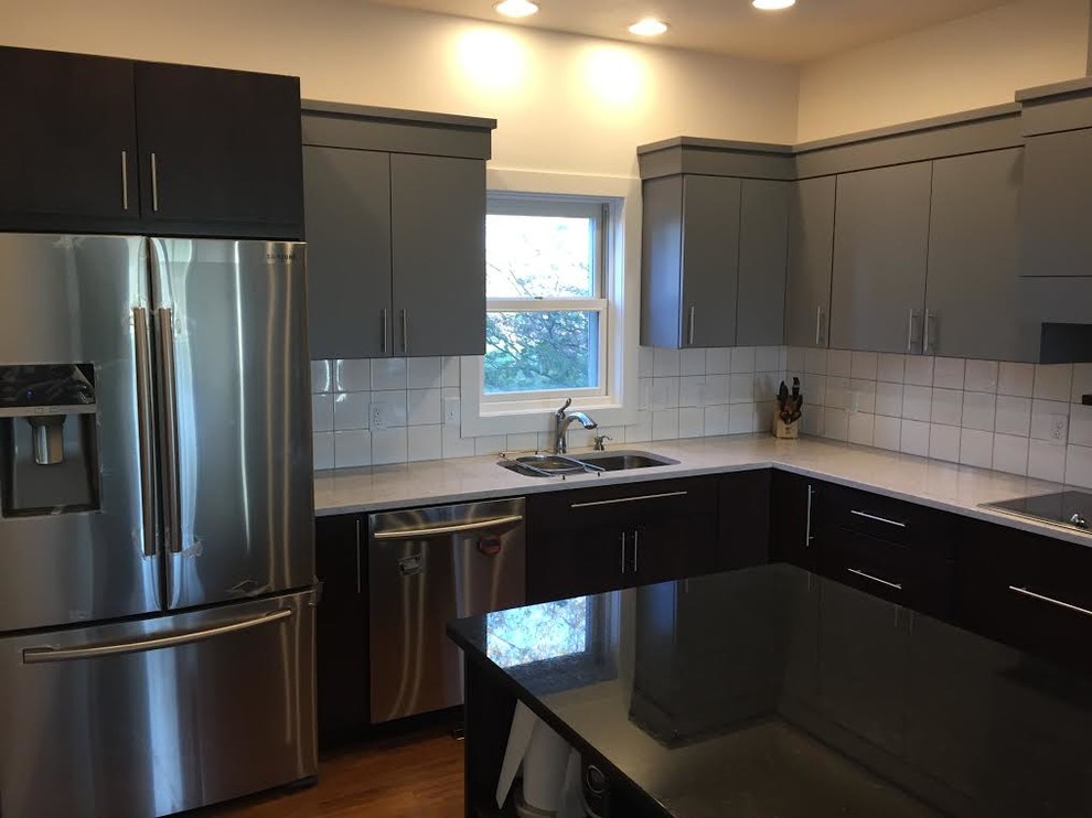 Eat-in kitchen - mid-sized transitional single-wall medium tone wood floor eat-in kitchen idea in Cedar Rapids with a double-bowl sink, flat-panel cabinets, gray cabinets, quartz countertops, white backsplash, ceramic backsplash, stainless steel appliances and an island