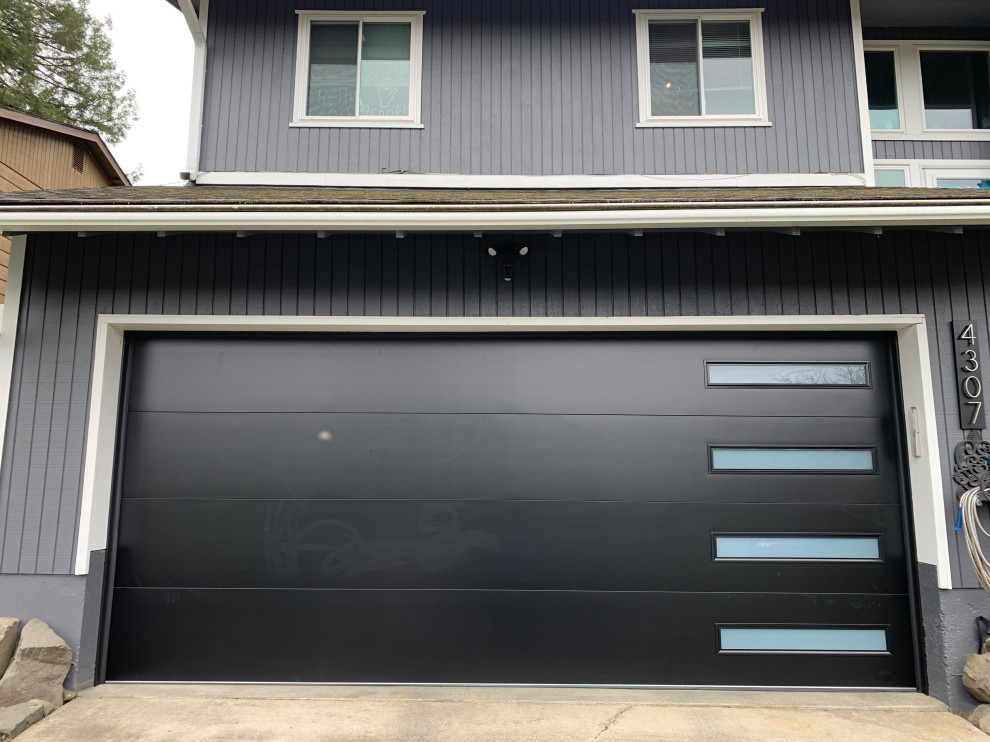 Cette image montre un garage pour deux voitures attenant minimaliste de taille moyenne avec une porte cochère.