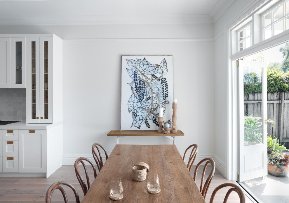 Photo of a large transitional open plan dining in Sydney with white walls, light hardwood floors and beige floor.