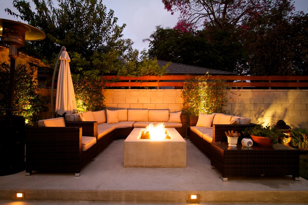 This is an example of a large contemporary backyard patio in Los Angeles with a fire feature, concrete slab and no cover.