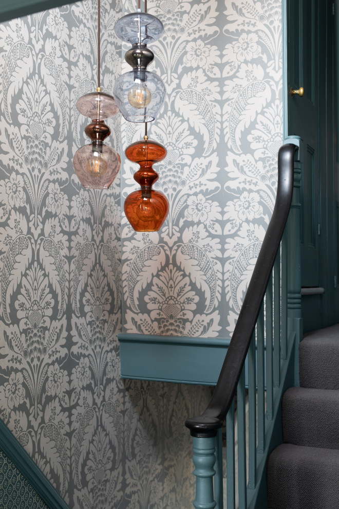 Photo of a mid-sized eclectic carpeted u-shaped staircase in Sussex with carpet risers, wood railing and wallpaper.