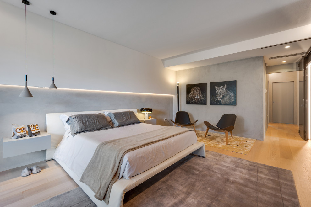 Immagine di una grande camera matrimoniale minimalista con pareti grigie, pavimento in legno verniciato e soffitto ribassato