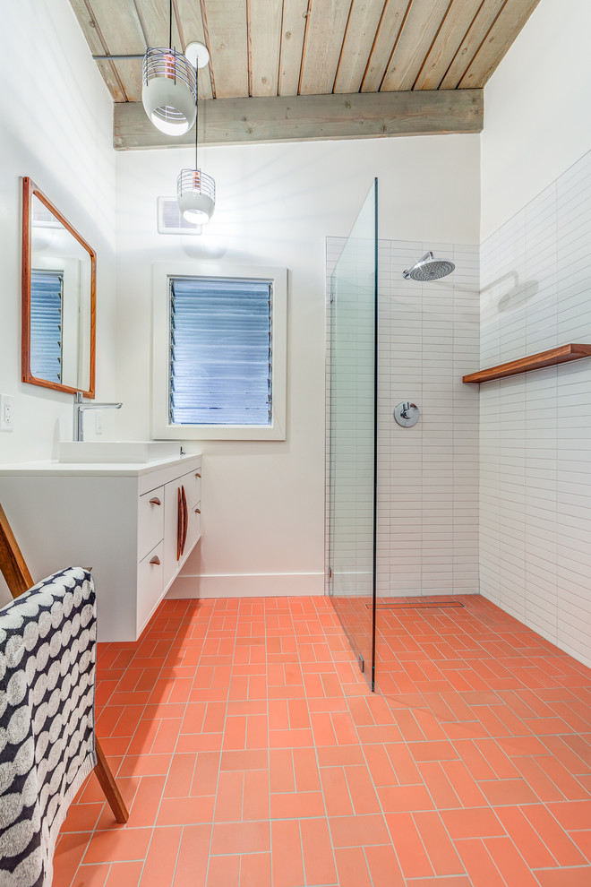 This is an example of a mid-sized midcentury 3/4 bathroom in San Francisco with flat-panel cabinets, white cabinets, a corner shower, white tile, ceramic tile, white walls, a vessel sink, engineered quartz benchtops, an open shower, white benchtops, brick floors and red floor.