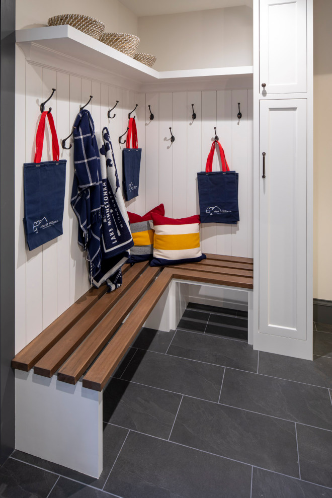 Inspiration for a mid-sized beach style mudroom in Minneapolis with ceramic floors, a single front door, a light wood front door and planked wall panelling.