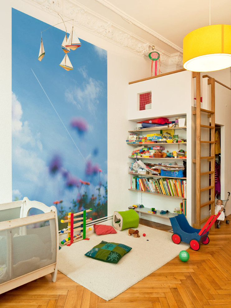 Design ideas for a mid-sized traditional kids' playroom for girls and kids 4-10 years old in Berlin with multi-coloured walls and light hardwood floors.