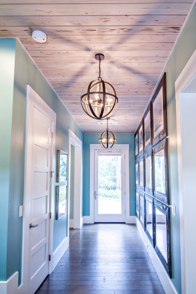 This is an example of a large tropical hallway in Jacksonville with blue walls and dark hardwood floors.