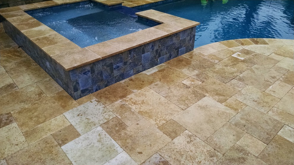 Modelo de piscinas y jacuzzis alargados costeros de tamaño medio a medida en patio trasero con adoquines de piedra natural
