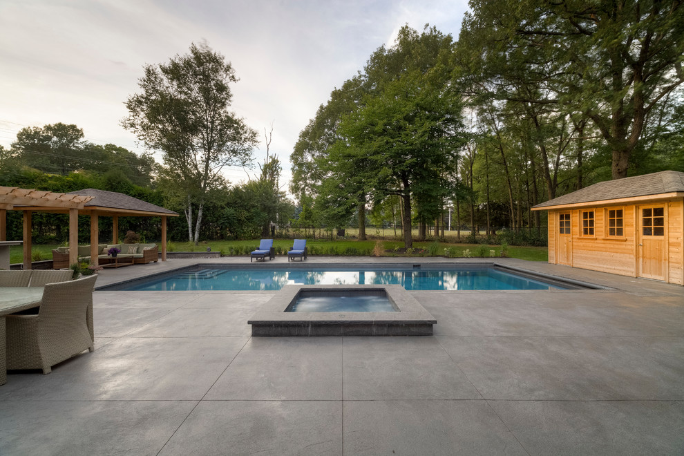 Design ideas for a mid-sized transitional backyard rectangular lap pool in Toronto with a hot tub and concrete pavers.