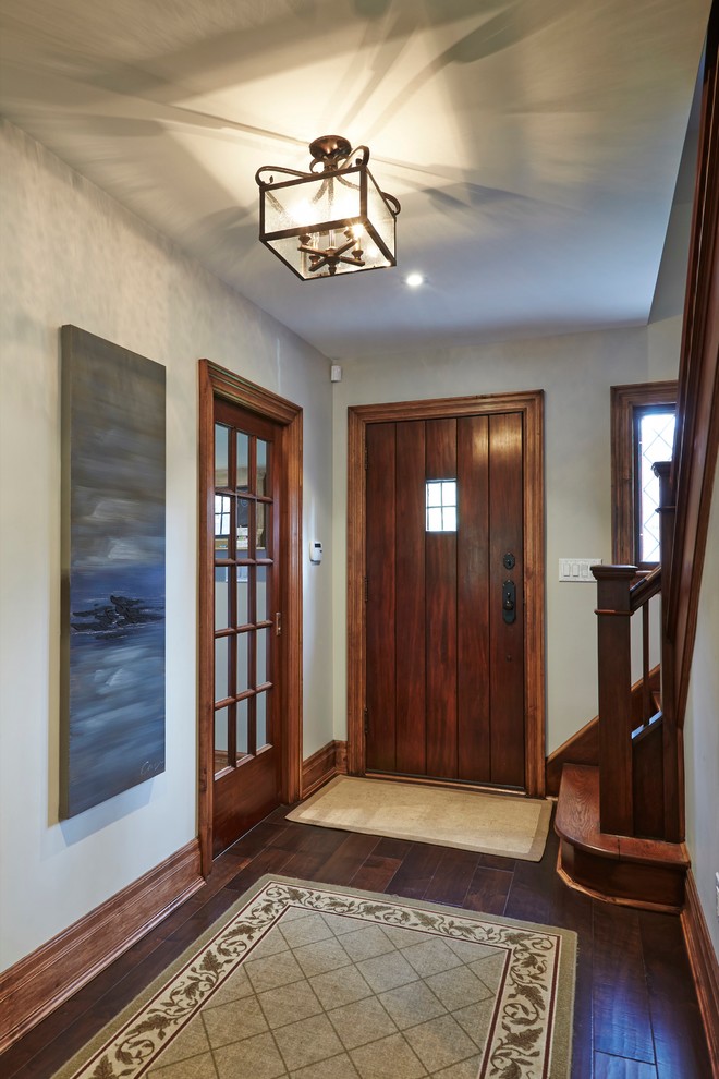 Design ideas for a mid-sized traditional foyer in Toronto with grey walls, medium hardwood floors, a single front door and a medium wood front door.