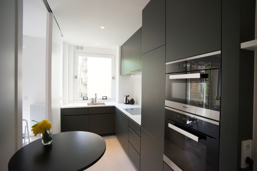 Foto på ett mellanstort funkis kök, med en undermonterad diskho, luckor med profilerade fronter, gröna skåp, bänkskiva i kvarts, vitt stänkskydd, integrerade vitvaror, klinkergolv i keramik, en köksö och beiget golv