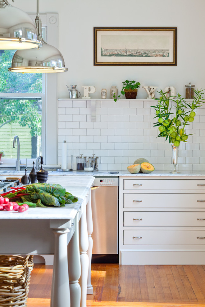 Inspiration for a traditional kitchen in Providence with beaded inset cabinets, white cabinets, white splashback, subway tile splashback, stainless steel appliances, medium hardwood floors and with island.