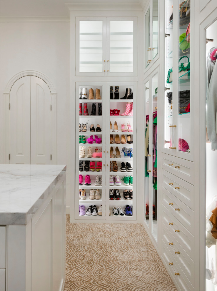 This is an example of a large transitional gender-neutral walk-in wardrobe in Dallas with beaded inset cabinets, white cabinets, carpet and beige floor.