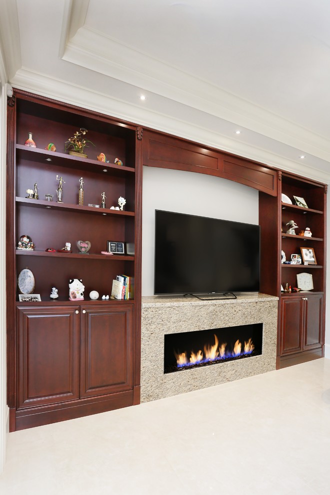 This is an example of an expansive traditional open concept living room in Vancouver with a library, white walls, marble floors, a standard fireplace, a wood fireplace surround and a built-in media wall.