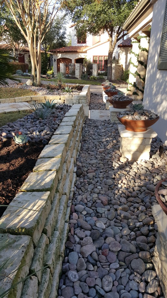 Photo of a mid-sized contemporary side yard partial sun xeriscape in Austin with a container garden and gravel.