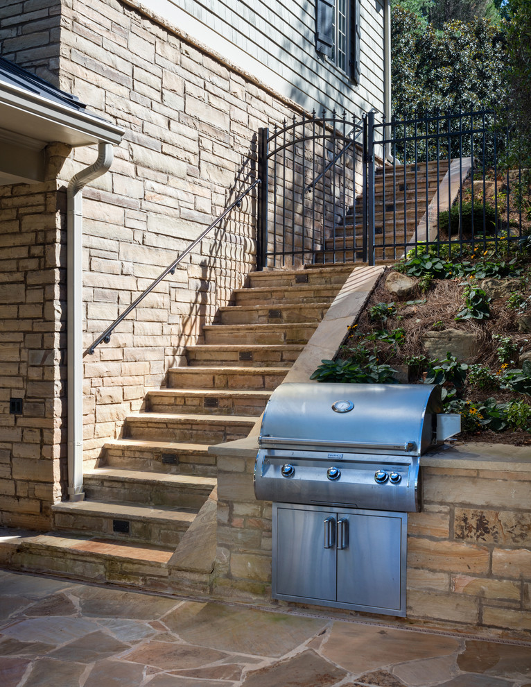 This is an example of a mid-sized traditional backyard patio in Atlanta with an outdoor kitchen, brick pavers and no cover.