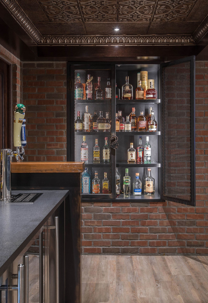 Photo of a large industrial galley seated home bar in Detroit with vinyl floors, beige floor, black cabinets, wood benchtops, red splashback, brown benchtop, an undermount sink and brick splashback.