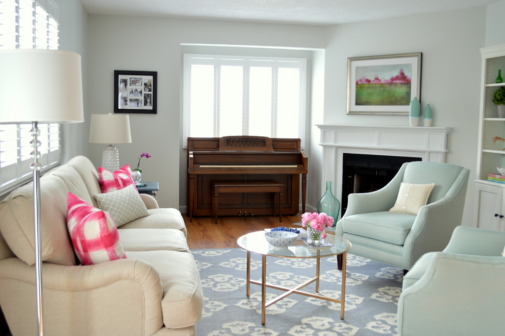This is an example of a small transitional enclosed living room in Boston with grey walls, medium hardwood floors, a standard fireplace and a wood fireplace surround.