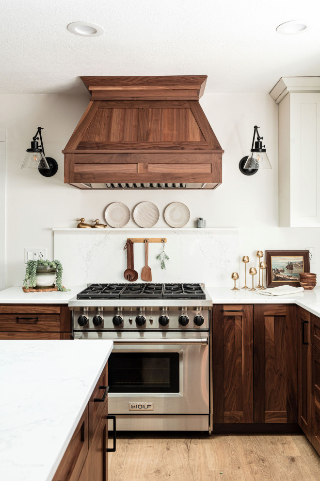 Large scandinavian eat-in kitchen in Minneapolis with shaker cabinets, dark wood cabinets, marble benchtops, marble splashback, stainless steel appliances, light hardwood floors, with island and white benchtop.