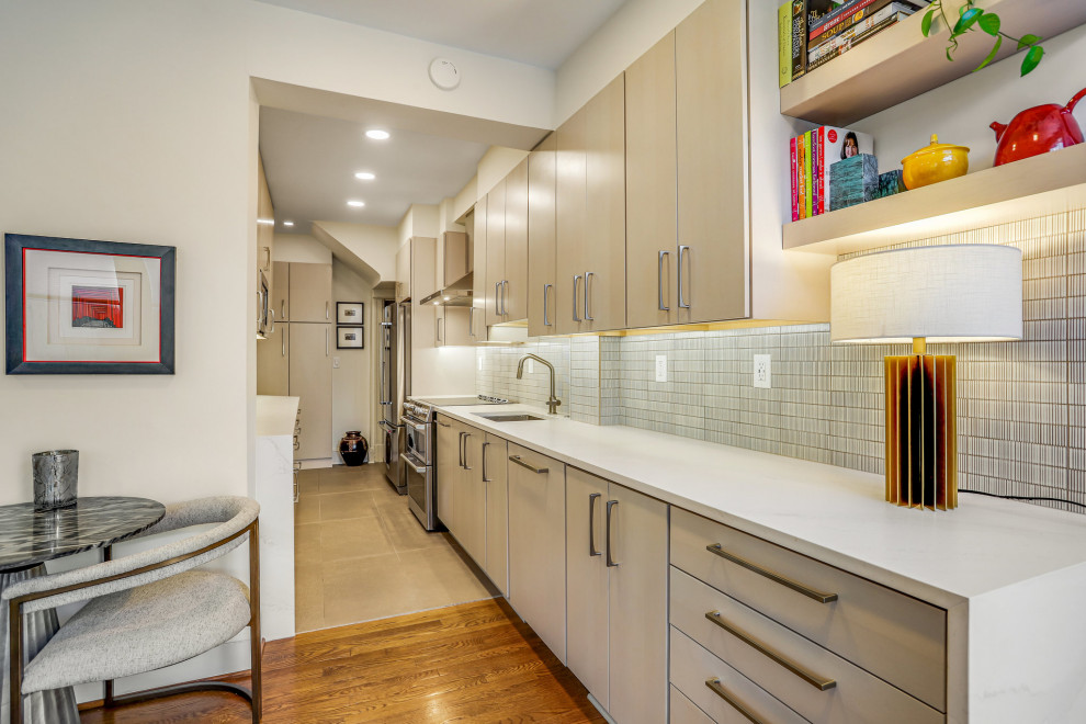 Kitchen pantry - mid-sized transitional galley kitchen pantry idea in DC Metro with a drop-in sink, flat-panel cabinets, light wood cabinets, stainless steel appliances and no island