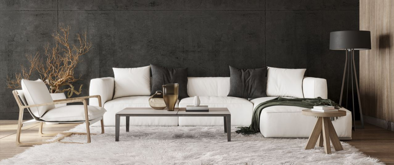 Modern living room with white couch, dark grey accents and hints of light wood throughout.