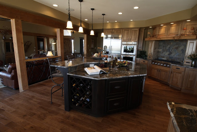 Open concept kitchen - large rustic u-shaped medium tone wood floor open concept kitchen idea with a double-bowl sink, beaded inset cabinets, medium tone wood cabinets, granite countertops, stainless steel appliances and an island