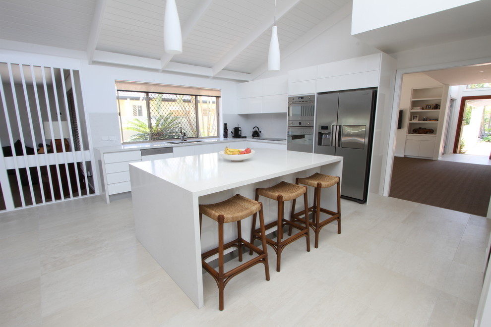 Design ideas for a mid-sized contemporary l-shaped open plan kitchen in Brisbane with a double-bowl sink, flat-panel cabinets, white cabinets, quartz benchtops, white splashback, porcelain splashback, stainless steel appliances, ceramic floors and with island.