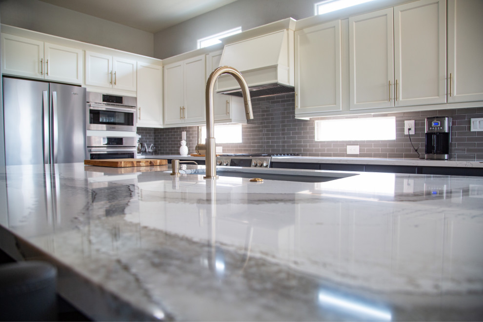 Inspiration for a mid-sized transitional l-shaped eat-in kitchen in Sacramento with an undermount sink, shaker cabinets, beige cabinets, quartz benchtops, glass tile splashback, stainless steel appliances and with island.