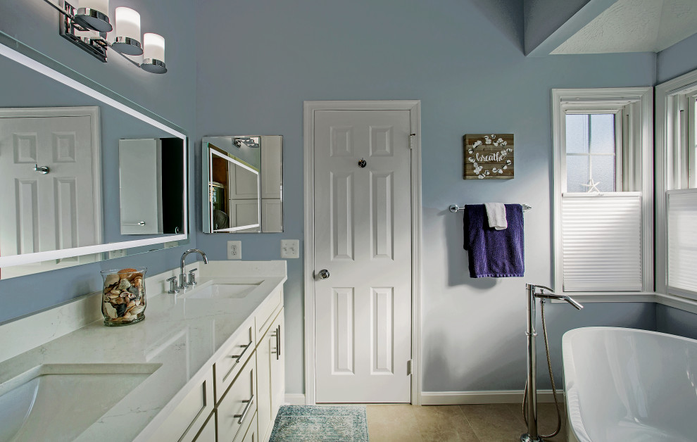 Идея дизайна: главная ванная комната среднего размера в стиле неоклассика (современная классика) с фасадами в стиле шейкер, белыми фасадами, отдельно стоящей ванной, душем в нише, раздельным унитазом, разноцветной плиткой, галечной плиткой, синими стенами, полом из керамогранита, врезной раковиной, столешницей из искусственного кварца, бежевым полом, душем с распашными дверями, белой столешницей, нишей, тумбой под две раковины, встроенной тумбой и сводчатым потолком