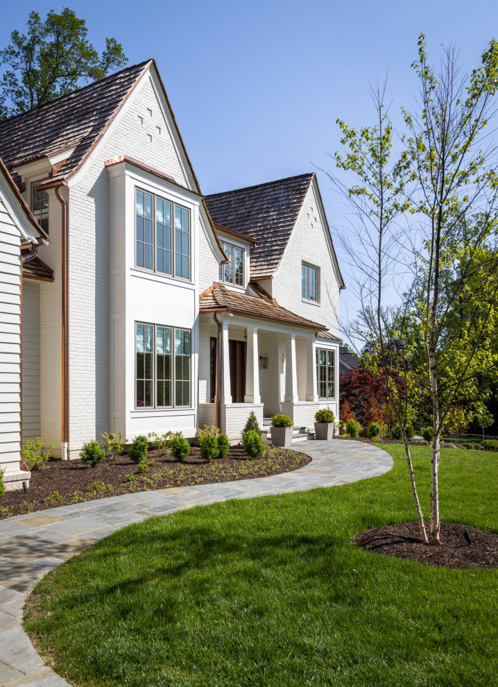 Foto de fachada de casa blanca y marrón grande de dos plantas con revestimientos combinados