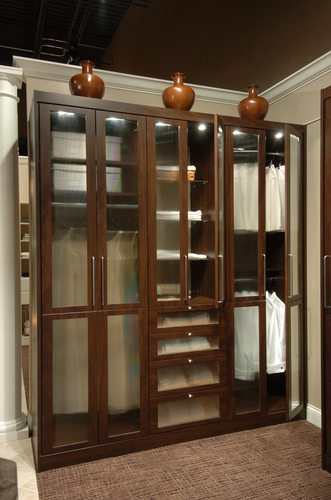 Photo of a contemporary storage and wardrobe in New York with raised-panel cabinets, dark wood cabinets and medium hardwood floors.