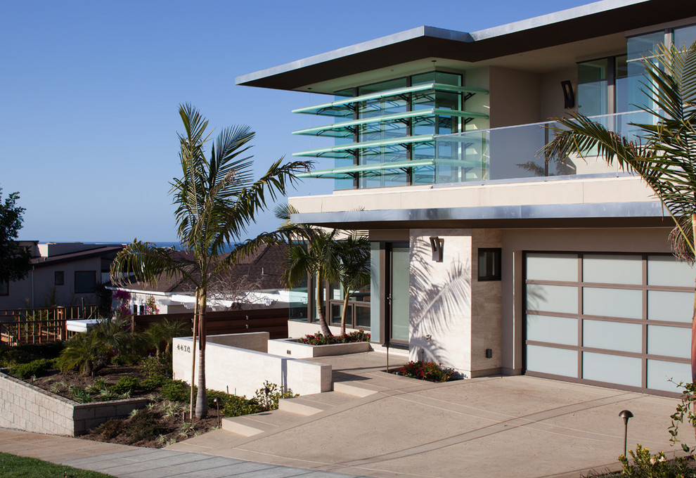 Photo of a mid-sized contemporary two-storey beige exterior in San Diego with stone veneer and a flat roof.
