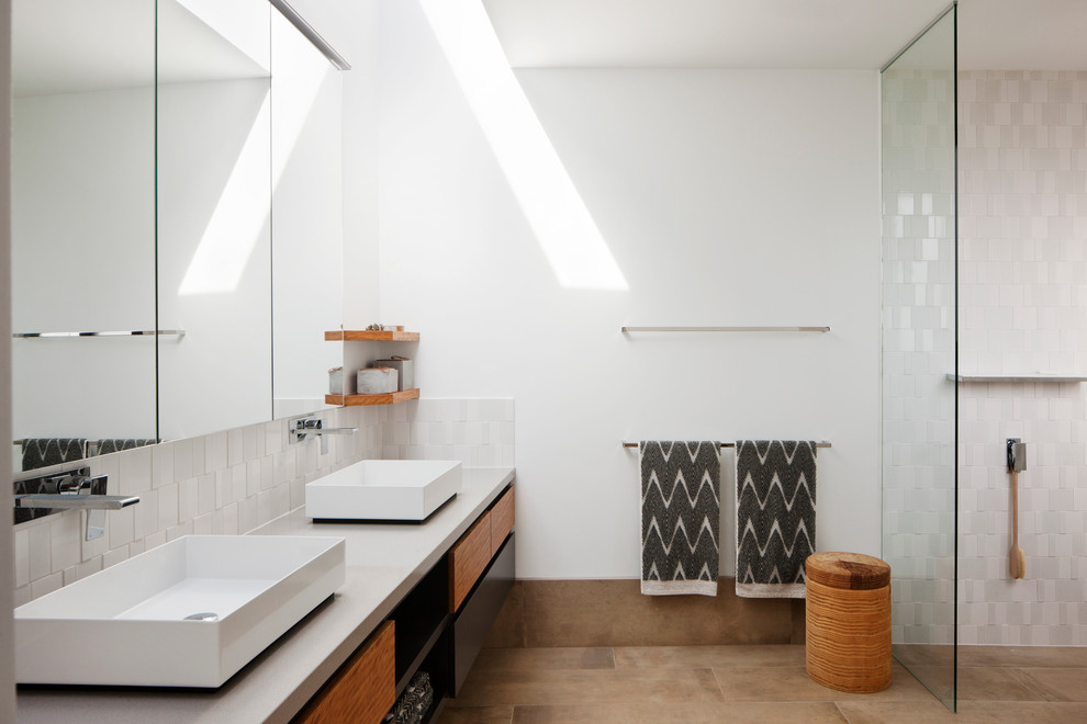 Photo of a large contemporary master bathroom in Melbourne with flat-panel cabinets, light wood cabinets, an open shower, a wall-mount toilet, white tile, ceramic tile, white walls, ceramic floors, a vessel sink, beige floor, an open shower and grey benchtops.