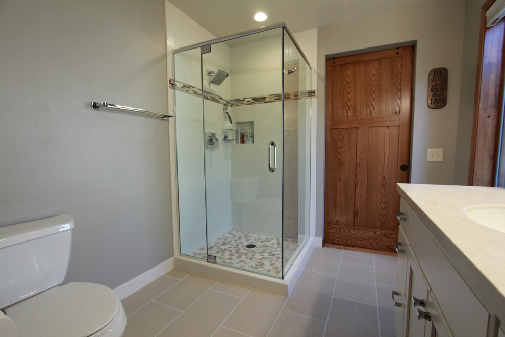Inspiration for a mid-sized arts and crafts master bathroom in Other with a corner shower, a one-piece toilet, ceramic floors, a drop-in sink, beige floor and a hinged shower door.