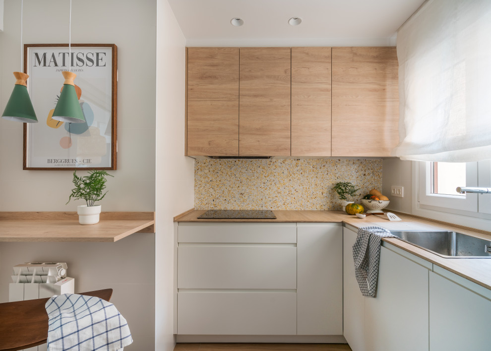 Design ideas for a small mediterranean u-shaped separate kitchen in Bilbao with a farmhouse sink, flat-panel cabinets, white cabinets, wood benchtops, multi-coloured splashback, terra-cotta splashback, panelled appliances, ceramic floors, no island, brown floor and brown benchtop.
