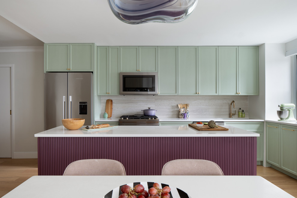 Example of a mid-sized transitional light wood floor eat-in kitchen design in New York with an undermount sink, green cabinets, quartz countertops, beige backsplash, porcelain backsplash, stainless steel appliances, an island and white countertops