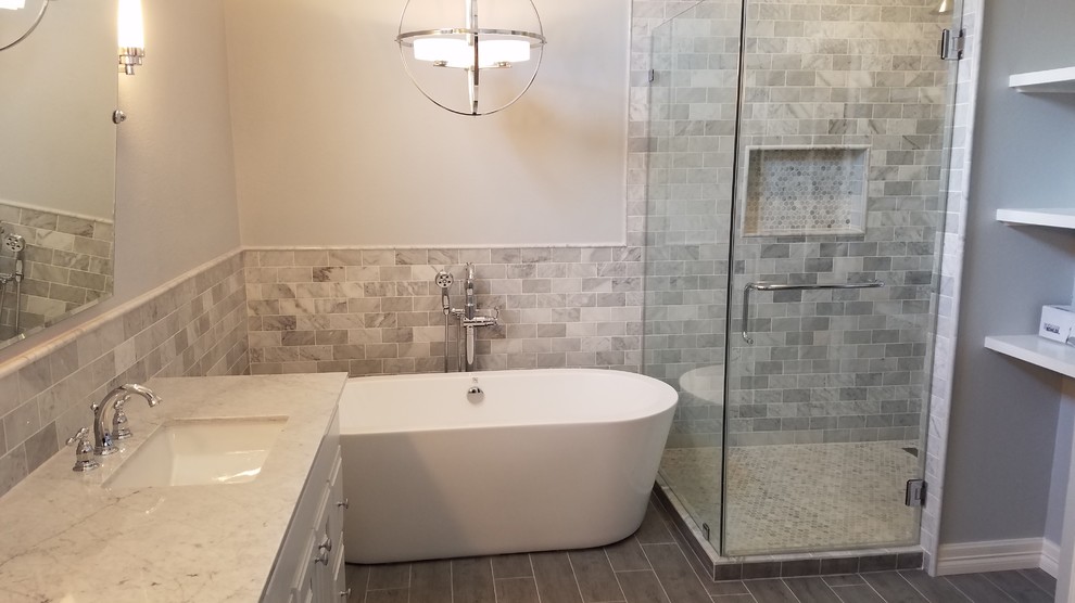 Design ideas for a mid-sized contemporary master bathroom in Houston with raised-panel cabinets, white cabinets, a freestanding tub, an alcove shower, gray tile, multi-coloured tile, white tile, marble, multi-coloured walls, ceramic floors, an undermount sink, marble benchtops, grey floor and a hinged shower door.