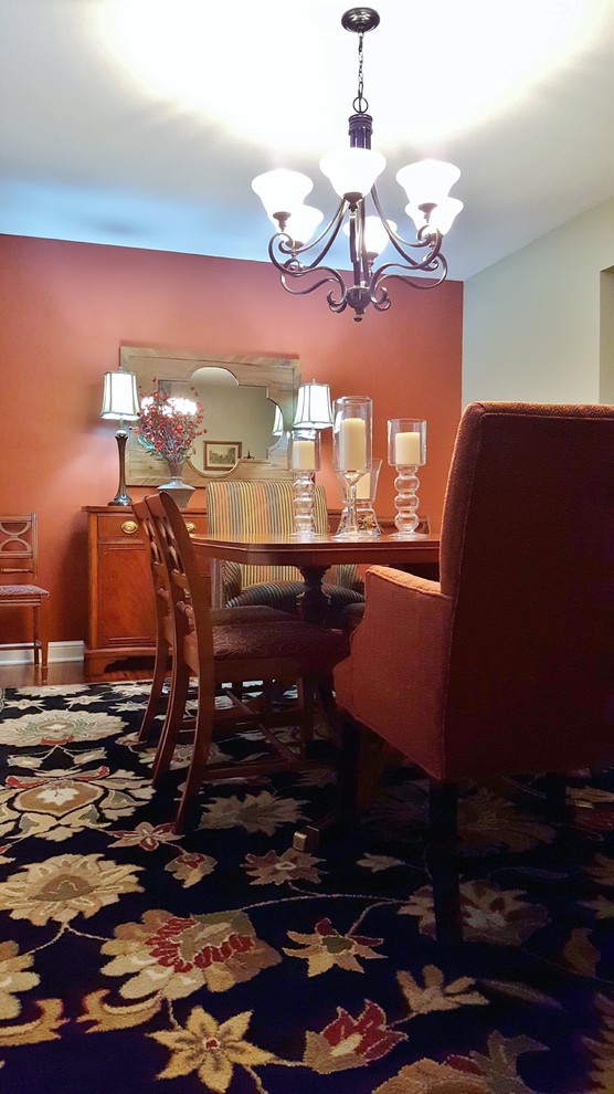 Photo of a mid-sized traditional separate dining room in Other with orange walls, medium hardwood floors, no fireplace and brown floor.