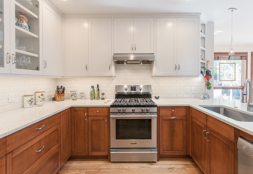 Inspiration for a transitional light wood floor kitchen remodel with a double-bowl sink, shaker cabinets, quartz countertops, white backsplash, subway tile backsplash and stainless steel appliances