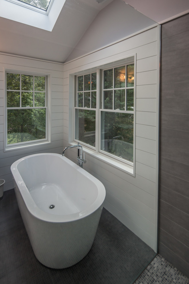Example of a large transitional master gray tile and porcelain tile porcelain tile freestanding bathtub design in Boston with recessed-panel cabinets, gray cabinets, a one-piece toilet, blue walls, an undermount sink and quartzite countertops