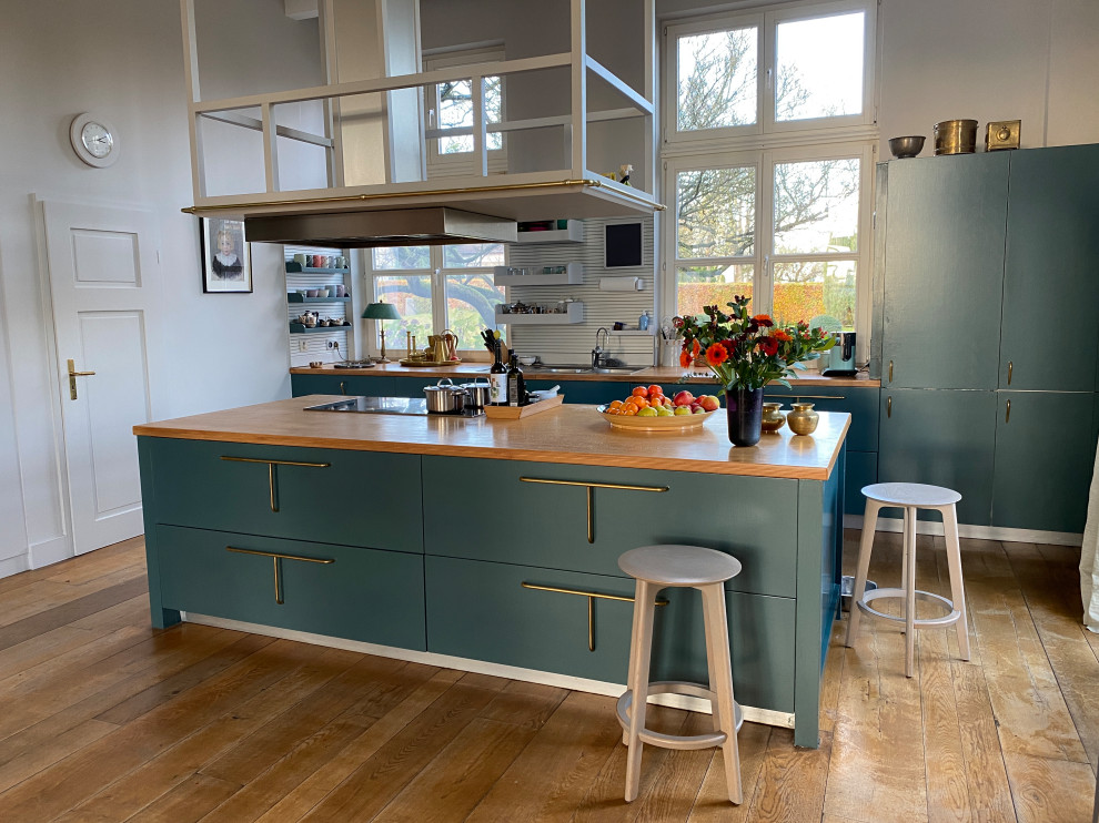 Offene, Zweizeilige, Große Country Küche mit Doppelwaschbecken, blauen Schränken, Arbeitsplatte aus Holz, Küchenrückwand in Blau, hellem Holzboden und Kücheninsel in Sonstige
