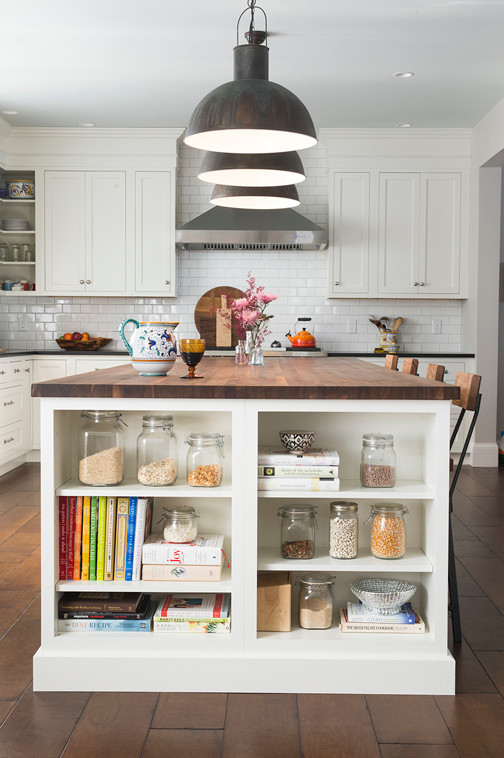 Example of a large transitional l-shaped dark wood floor and brown floor eat-in kitchen design in Burlington with a single-bowl sink, shaker cabinets, white cabinets, soapstone countertops, white backsplash, ceramic backsplash, stainless steel appliances, an island and black countertops