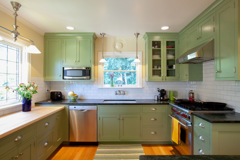 Inspiration for an arts and crafts kitchen in Seattle with stainless steel appliances, wood benchtops, shaker cabinets, green cabinets, white splashback and subway tile splashback.
