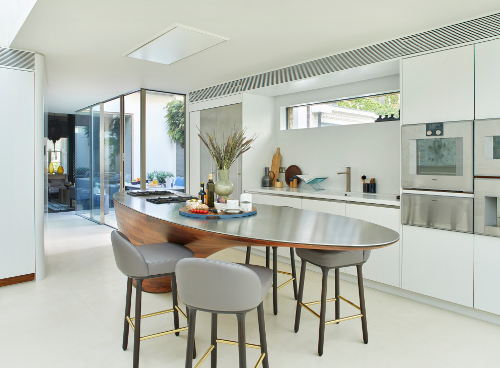 Design ideas for a contemporary galley kitchen in London with a submerged sink, flat-panel cabinets, white cabinets, stainless steel appliances, an island, white floors and white worktops.