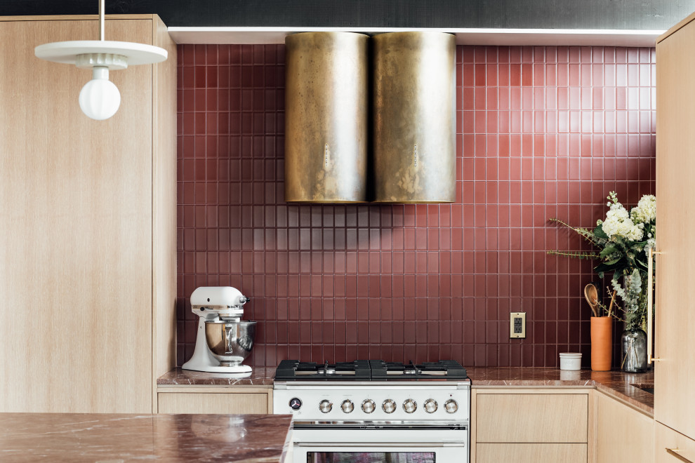 Foto på ett mellanstort retro röd kök, med en integrerad diskho, släta luckor, skåp i ljust trä, marmorbänkskiva, rött stänkskydd, stänkskydd i glaskakel, vita vitvaror, terrazzogolv, en halv köksö och grått golv