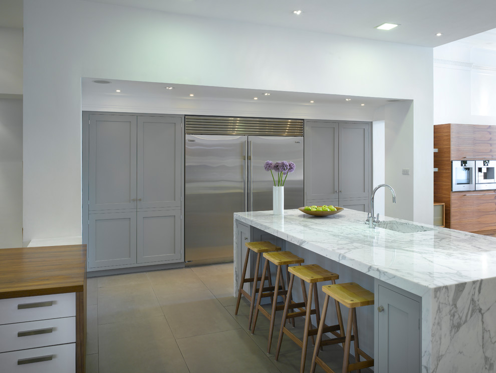 Photo of a large contemporary open plan kitchen in London with shaker cabinets, grey cabinets, marble benchtops, stainless steel appliances, with island, an undermount sink and ceramic floors.