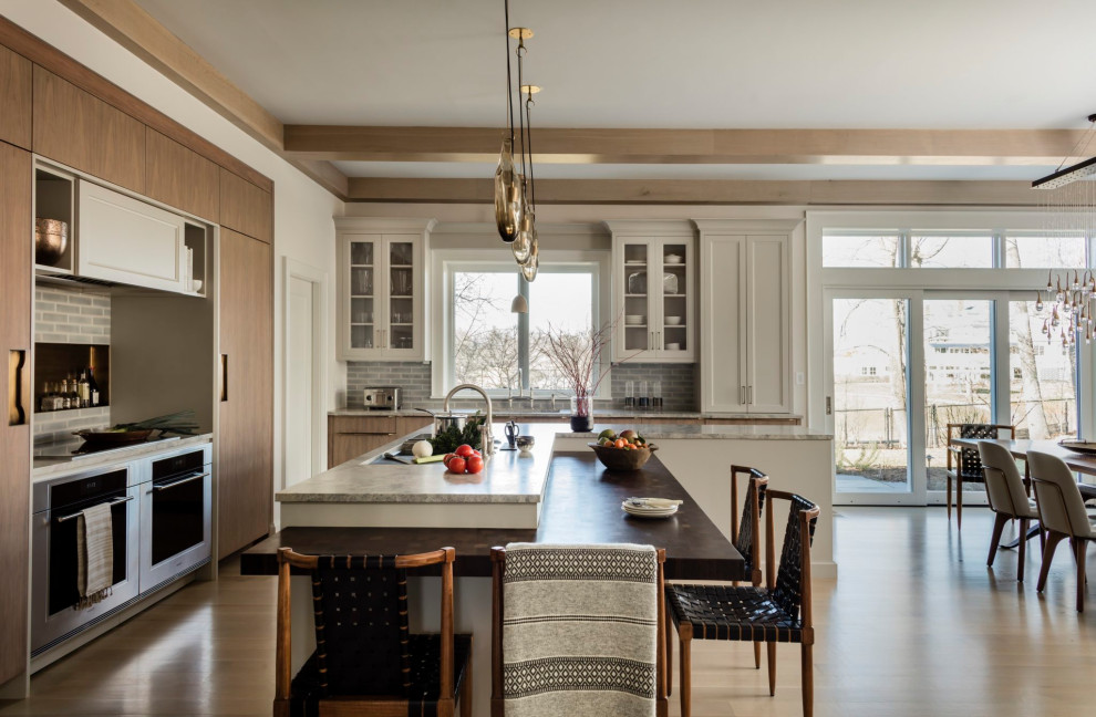 Eat-in kitchen - large transitional light wood floor and brown floor eat-in kitchen idea in Boston with flat-panel cabinets, medium tone wood cabinets, marble countertops, gray backsplash, brick backsplash, stainless steel appliances, an island and gray countertops