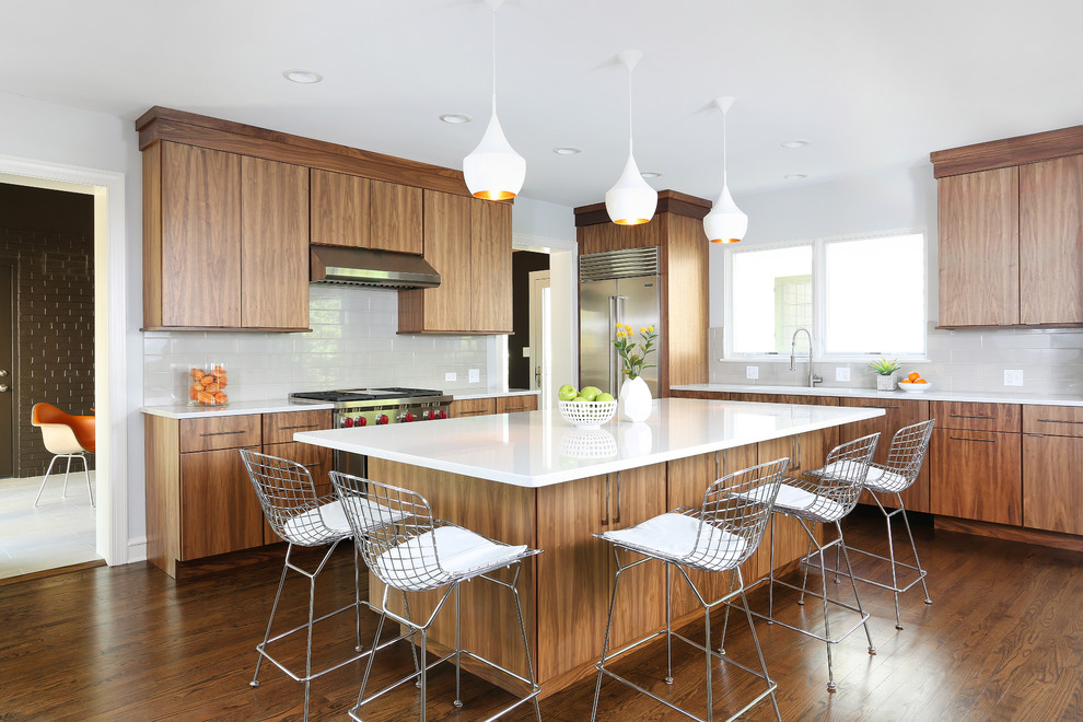 Inspiration for a large midcentury l-shaped eat-in kitchen in Chicago with a single-bowl sink, flat-panel cabinets, brown cabinets, stainless steel appliances, with island, quartz benchtops, white splashback, ceramic splashback and dark hardwood floors.