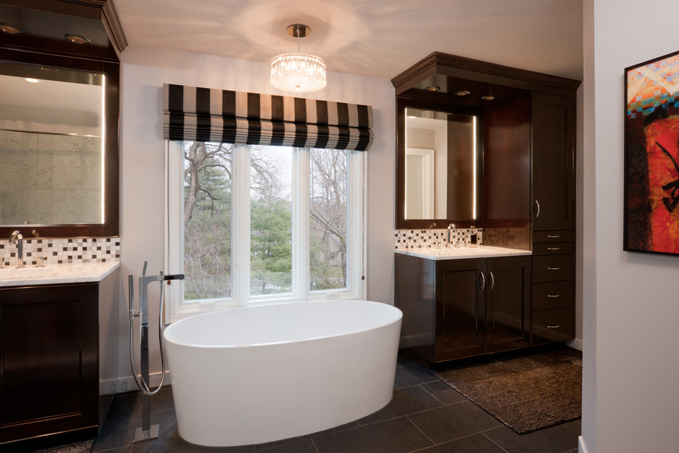 Inspiration for a large transitional master bathroom in Houston with an undermount sink, raised-panel cabinets, dark wood cabinets, marble benchtops, a freestanding tub, a corner shower, white tile, glass tile, white walls, porcelain floors, brown floor and a hinged shower door.